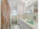 Bathroom featuring double sinks with original green basins, tiled walls, and a framed mirror above the vanity at 6994 Nw 320 Hwy, Micanopy, FL 32667