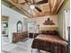 Inviting bedroom featuring a comfortable bed, wooden dresser, ceiling fan and unique wall decor at 6994 Nw 320 Hwy, Micanopy, FL 32667