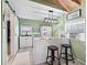 Charming kitchen with white cabinets, butcher block bar, and rustic stool seating at 6994 Nw 320 Hwy, Micanopy, FL 32667