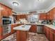 Kitchen showcasing wood cabinetry, white countertops, stainless steel appliances, and unique brick flooring at 6994 Nw 320 Hwy, Micanopy, FL 32667