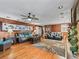 Spacious living room showcasing wood floors, wood paneling, and comfortable seating arrangement at 6994 Nw 320 Hwy, Micanopy, FL 32667