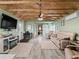 Inviting living room featuring a ceiling fan, a modern entertainment center, and comfortable beige leather seating at 6994 Nw 320 Hwy, Micanopy, FL 32667