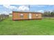 Exterior shot of a small wooden outbuilding with a green roof, with grassy lawn at 6994 Nw 320 Hwy, Micanopy, FL 32667