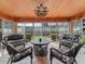 Sunroom featuring four cushioned chairs, a round table, and views of the backyard at 6994 Nw 320 Hwy, Micanopy, FL 32667