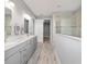 Bright bathroom featuring a double vanity with grey cabinets and wood-look tile flooring at 8107 Sw 92Nd Cir, Ocala, FL 34481