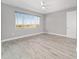 A spacious light-filled bedroom with a ceiling fan, wood look floors and a large window at 8107 Sw 92Nd Cir, Ocala, FL 34481