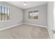 Bright bedroom with neutral walls, carpet floors, ceiling fan, and natural light from two windows at 8107 Sw 92Nd Cir, Ocala, FL 34481