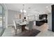 Elegant dining room showcases a modern chandelier, marble table, and open access to the kitchen at 8107 Sw 92Nd Cir, Ocala, FL 34481