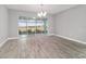 Bright dining room with wood-look tile floors, modern chandelier, and sliding glass doors to the lanai at 8107 Sw 92Nd Cir, Ocala, FL 34481