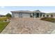 Paver driveway leading to a charming one-story home with a two-car garage and inviting curb appeal at 8107 Sw 92Nd Cir, Ocala, FL 34481