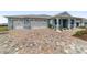 Paver driveway leading to a two-car garage and charming home with shutters and a cozy front porch at 8107 Sw 92Nd Cir, Ocala, FL 34481