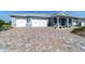 Charming single-story home featuring a brick driveway, two-car garage, and a manicured front yard at 8107 Sw 92Nd Cir, Ocala, FL 34481