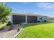 Back exterior with an enclosed lanai, lush green lawn, and neatly landscaped flower beds at 8107 Sw 92Nd Cir, Ocala, FL 34481