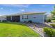 Rear exterior showing a well-manicured lawn, neat landscaping, and screened-in lanai at 8107 Sw 92Nd Cir, Ocala, FL 34481