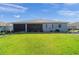 Back exterior view with a well-maintained lawn, landscaping, and screened-in lanai at 8107 Sw 92Nd Cir, Ocala, FL 34481