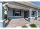 Inviting covered front porch with brick pavers and decorative columns and fresh landscaping at 8107 Sw 92Nd Cir, Ocala, FL 34481