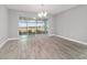 Bright living room featuring sliding glass doors, wood floors, and a modern chandelier at 8107 Sw 92Nd Cir, Ocala, FL 34481