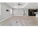 Living room with wood-look tile flooring connects to kitchen and has views from windows and sliding glass doors at 8107 Sw 92Nd Cir, Ocala, FL 34481