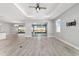 Open-concept living room featuring a tray ceiling, ceiling fan, and sliding glass doors to the patio at 8107 Sw 92Nd Cir, Ocala, FL 34481