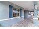 Covered porch featuring brick pavers, blue shutters, and stylish architectural details at 8107 Sw 92Nd Cir, Ocala, FL 34481