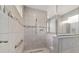 Shower featuring neutral tile, glass surround, shower niche, and metal grab bar at 8107 Sw 92Nd Cir, Ocala, FL 34481