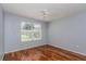 Bedroom with wood-look floors, ceiling fan, and a large window at 8231 Sw 108Th Loop, Ocala, FL 34481