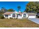 Charming single-story white home with a well-manicured front yard and attached garage at 8231 Sw 108Th Loop, Ocala, FL 34481