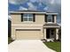 Two-story home featuring a large garage, neutral stucco, dark shutters, and a well-manicured lawn at 8673 Sw 44Th Ter, Ocala, FL 34476