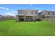 Exterior view of home's backyard, featuring a spacious lawn and covered patio at 8953 Sw 50Th Ter, Ocala, FL 34476