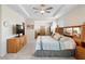 Spacious bedroom featuring a tray ceiling with fan, carpeted floors and an ensuite bathroom at 8953 Sw 50Th Ter, Ocala, FL 34476