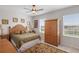 Bright bedroom featuring palm tree decor, a ceiling fan and plantation shutters at 8953 Sw 50Th Ter, Ocala, FL 34476