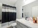 Bathroom featuring a gray vanity, sink, toilet, and shower-tub combo at 9105 Se 55Th Ter, Ocala, FL 34480