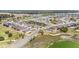 Aerial view of a well-planned community featuring a golf course, lake, and modern homes with manicured lawns at 9184 Sw 57Th Place Rd, Ocala, FL 34481