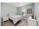 This bedroom features light-blue walls, a floral patterned comforter, a ceiling fan, and wood-look floors at 9184 Sw 57Th Place Rd, Ocala, FL 34481