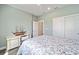 This bedroom features light-blue walls, a floral patterned comforter, a ceiling fan, and wood-look floors at 9184 Sw 57Th Place Rd, Ocala, FL 34481