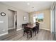 A dining room with wood-look floors, a table with seating for six, and bright natural light at 9184 Sw 57Th Place Rd, Ocala, FL 34481