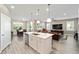 Open concept kitchen with stainless steel appliances, white cabinets, an island, and a view of the living area at 9184 Sw 57Th Place Rd, Ocala, FL 34481