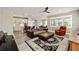 Open concept living room with a ceiling fan, leather sofa, and a view of the kitchen and dining area at 9184 Sw 57Th Place Rd, Ocala, FL 34481