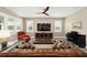 Bright living room with a large window, ceiling fan, leather sofa, and a piano, creating a cozy space at 9184 Sw 57Th Place Rd, Ocala, FL 34481