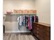 This walk-in closet features a shelf, hanging rack, wooden dresser, and wood-look floors at 9184 Sw 57Th Place Rd, Ocala, FL 34481