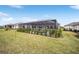 Expansive backyard showcasing a well-manicured lawn leading up to the screened-in patio and lush landscaping at 9270 Sw 89Th Street Rd, Ocala, FL 34481