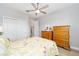 Bright bedroom with a floral quilt, wooden dressers, and a large window at 9270 Sw 89Th Street Rd, Ocala, FL 34481