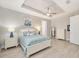 Well-lit bedroom boasts a tray ceiling, neutral walls, and ample natural light at 9270 Sw 89Th Street Rd, Ocala, FL 34481