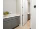 Hallway with grey cabinets, light countertops, and neutral paint, leading to another room with similar cabinetry at 9270 Sw 89Th Street Rd, Ocala, FL 34481