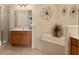 Elegant bathroom with a soaking tub and wooden vanity at 9274 Sw 94Th Loop, Ocala, FL 34481