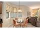 Cozy dining area with glass table, chairs, and three sunny windows at 9274 Sw 94Th Loop, Ocala, FL 34481