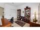 A home office featuring two wooden shelves, a large desk, and natural light from the windows at 9274 Sw 94Th Loop, Ocala, FL 34481