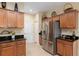 Bright kitchen featuring stainless steel refrigerator, granite counters, and wooden cabinets at 9274 Sw 94Th Loop, Ocala, FL 34481