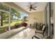 Comfortable screened lanai with chairs and ceiling fan overlooking a lush backyard at 9274 Sw 94Th Loop, Ocala, FL 34481