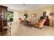 Bright living room with a sliding glass door to the patio, comfortable seating, and neutral tile flooring at 9274 Sw 94Th Loop, Ocala, FL 34481